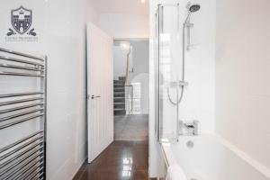 uma casa de banho branca com uma banheira e um chuveiro em Castle Properties: The Sovereign 5 Bed Town House em Windsor