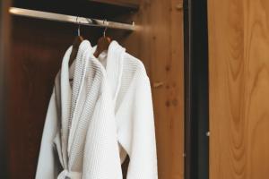 a row of white coats hanging on a rack at Georg Palace Hotel in Chernivtsi