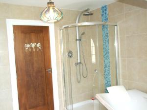 La salle de bains est pourvue d'une douche avec une porte en verre. dans l'établissement Glendalough 10 Minutes from Beautiful Farmhouse, à Roundwood