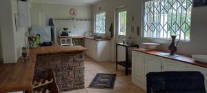 a kitchen with a counter and a brick fireplace at Dollery House in Port Alfred
