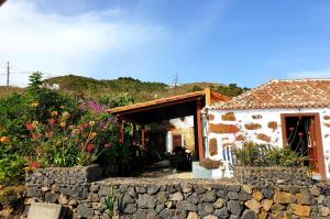 Casa pequeña con pared de piedra y puerta en Sara, en Puntallana