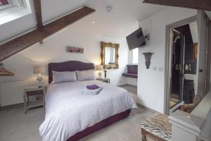 a bedroom with a large bed and a mirror at Cornerways Guest House in St Ives