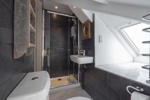 a bathroom with a toilet and a sink and a window at Cornerways Guest House in St Ives