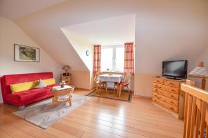 - un salon avec un canapé rouge et une télévision dans l'établissement Haus "Seeland 2" Appartement SEE209, à Duhnen