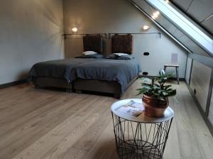 阿尼克什奇艾Palaima Hotel Anykščiai的一间卧室配有一张床和一张带盆栽的桌子