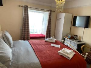a hotel room with a bed and a television at The Durbeyfield Guest House in West Bay