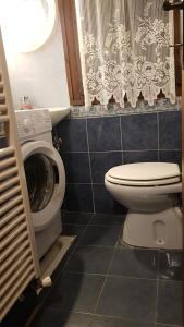 a bathroom with a toilet and a washing machine at Armida in Pescasseroli