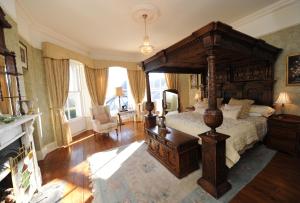 um quarto com uma grande cama de dossel e uma lareira em Corick House Hotel & Spa em Clogher