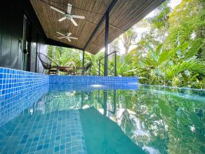 a swimming pool with a blue tile floor and a ceiling at Villa JOEYSHE- New Luxury Villa with Pool & AC in Puerto Viejo