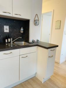a kitchen with white cabinets and a sink at Ankerplatz Timmendorfer Strand in Timmendorfer Strand