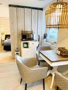 een woonkamer met een tafel en stoelen en een slaapkamer bij Ankerplatz Timmendorfer Strand in Timmendorfer Strand