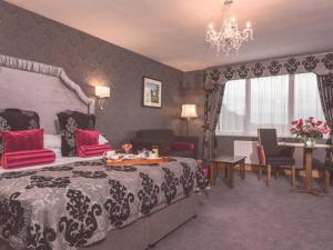 um quarto com uma cama grande, uma mesa e cadeiras em Corick House Hotel & Spa em Clogher