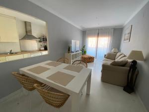 a living room with a table and a couch at Albatros Apartamentos Playa Granada in Motril