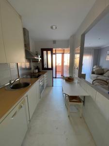 a kitchen with a sink and a table and a couch at Albatros Apartamentos Playa Granada in Motril