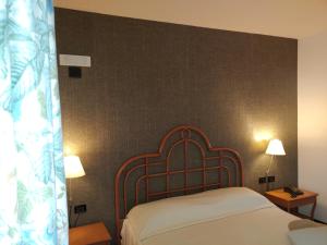 a bedroom with a bed and two night stands and two lamps at Locanda del Boscogrande in Montegrosso dʼAsti