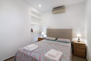 a bedroom with a bed with two towels on it at Adelino Guest House in Olhão
