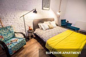 a bedroom with a bed and a chair in it at BpR Whistle Arts Industrial Apartment in Budapest