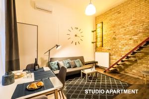 a living room with a couch and a clock on the wall at BpR Whistle Arts Industrial Apartment in Budapest