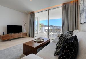 a living room with a couch and a tv at Luxury apt in the hills of Marbella in Ojén