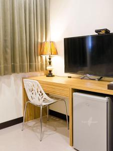 a desk with a television and a chair in a room at Tainan Yi Zhan in San-fen-tzu