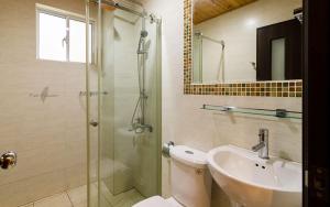 a bathroom with a shower and a toilet and a sink at Tainan Yi Zhan in San-fen-tzu