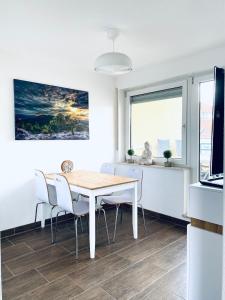 een eetkamer met een witte tafel en stoelen bij nJoy! Sunny & Simple - Dachterasse - gratis WLAN in Bad Friedrichshall