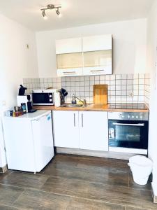 eine Küche mit weißen Schränken und weißen Geräten in der Unterkunft nJoy! Sunny & Simple - Dachterasse - gratis WLAN in Bad Friedrichshall