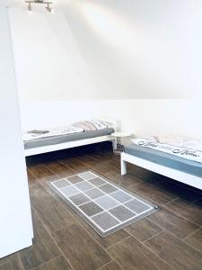 een kamer met 2 bedden en een houten vloer bij nJoy! Sunny & Simple - Dachterasse - gratis WLAN in Bad Friedrichshall