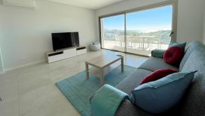 a living room with a couch and a tv and a table at Alvorada Premium by Sunny Deluxe in Albufeira