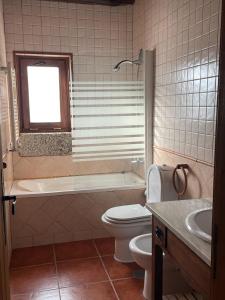 ein Badezimmer mit einem WC, einer Badewanne und einem Waschbecken in der Unterkunft Gerês - Casa do Paço in Rio Caldo