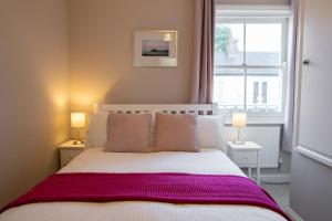 um quarto com uma cama com um cobertor roxo em Silverdale Mews em Eastbourne