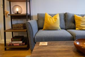 a living room with a blue couch with yellow pillows at Silverdale Mews in Eastbourne