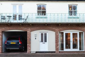 un coche aparcado dentro de un edificio de ladrillo con balcón en Silverdale Mews en Eastbourne