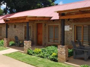 a small brick house with a red roof at The Stables At Critchley in Dullstroom