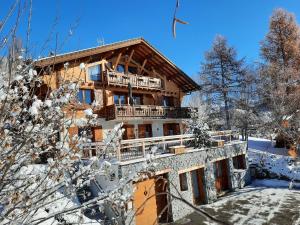 a log house in the snow with snow covered trees at Chalet Le Paradou in La Côte-dʼAime