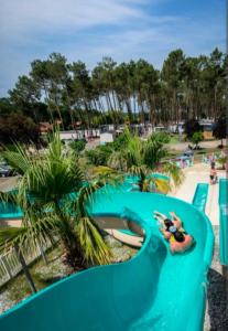 a person riding a water slide at a water park at Mobil home Rainbow, camping les dunes de contis in Saint-Julien-en-Born