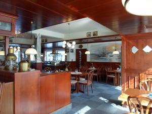 a restaurant with wooden walls and tables and chairs at Gästehaus Restaurant Norddeich in Norddeich