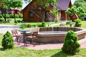 un patio con mesa y sillas frente a una casa en "Trakaitis" Entire Deluxe Villa, en Trakai