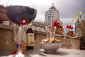 巴勒莫Scirocco House的一杯葡萄酒和一碗桌上的食物