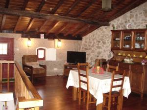 a living room with a table and chairs and a television at Casa Real Danaia in Germil