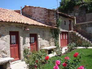 a group of buildings with red doors and flowers at Casa Real Danaia in Germil