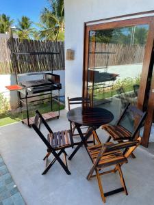 a patio with a table and two chairs and a grill at Casa Charme na Praia do Patacho-AL (prox.Milagres) in Pôrto de Pedras