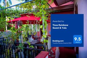 una señal frente a un restaurante con una sombrilla roja en Tissa Rainbow Guest & Yala en Tissamaharama