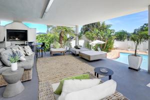 sala de estar con muebles blancos y piscina en The Model House, en Ciudad del Cabo