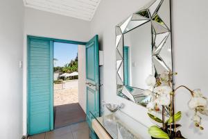 a bathroom with a blue door and a mirror at The Model House in Cape Town