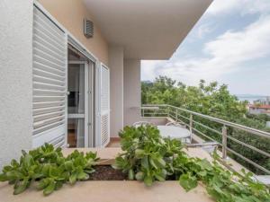 un balcón de una casa con bañera y plantas en Apartments Antonio, en Tučepi