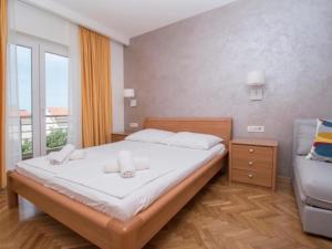 a bedroom with a bed and a couch and a window at Apartments Antonio in Tučepi
