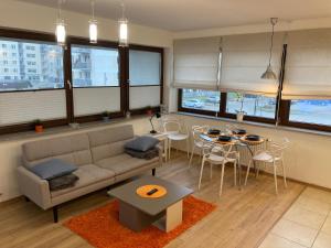 een woonkamer met een bank en een tafel en stoelen bij JAB Apartments Panoramika Business & Family in Szczecin