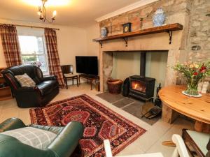 sala de estar con sofá y chimenea en The Old Bakery en Wooler