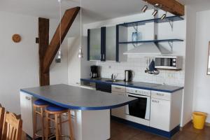 een keuken met blauwe aanrechtbladen en witte kasten bij Ferienhof " Dat grode Gulfhuus" in Tossens